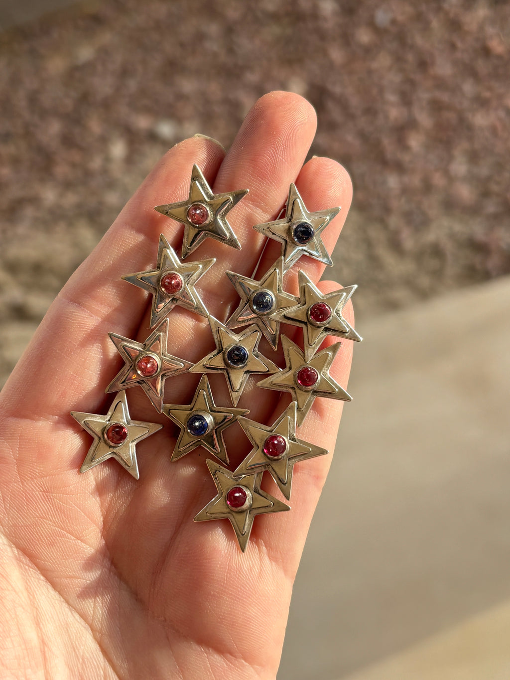 sterling silver star earrings with bezel set ruby, pink and blue sapphires